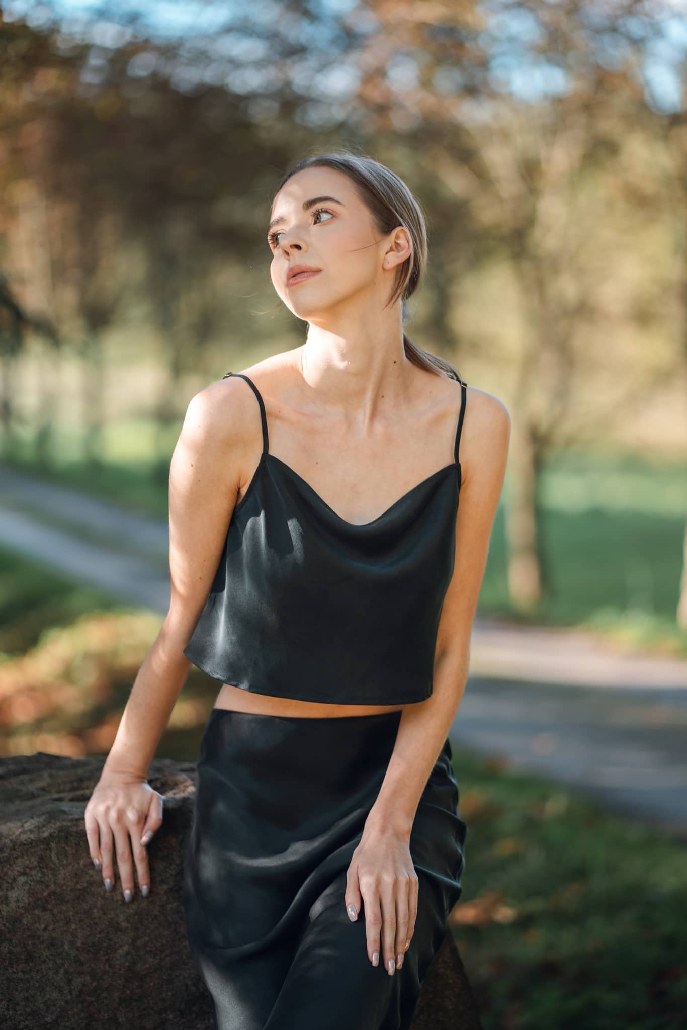 Woman wearing Silk Closet black cropped silk cami and matching silk skirt.