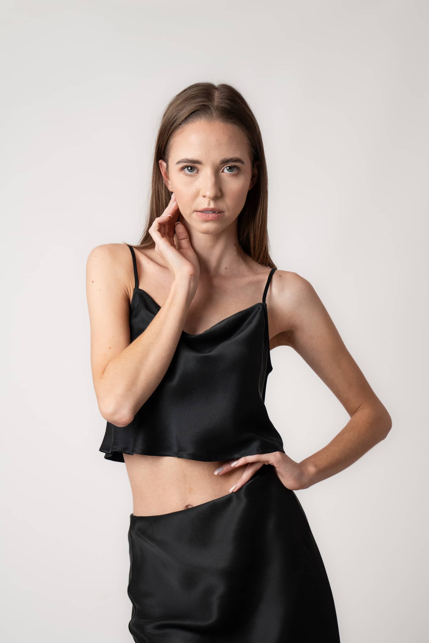 Woman wearing Silk Closet black cropped silk cami and matching silk skirt. Close up of floaty top.